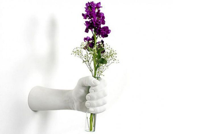 Неординарная ваза в форме руки, которая дарит цветы.