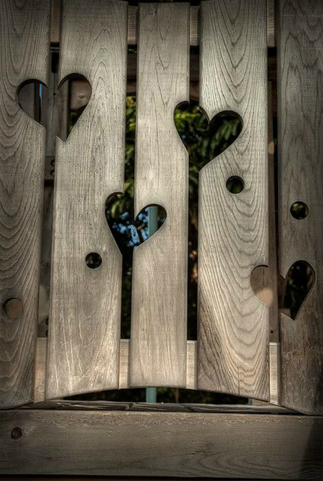 Деревянный забор с вырезанными сердцами.