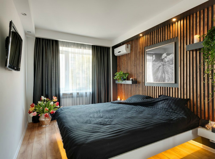 Стильная спальня с деревянной акцентной стеной.