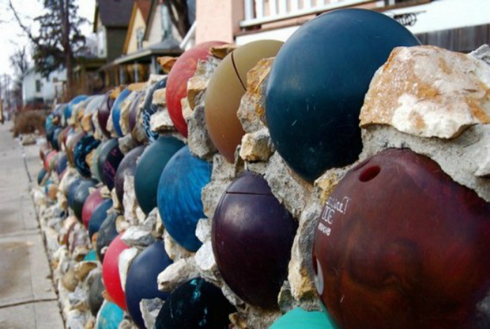 Забор, украшенный шарами для боулинга.