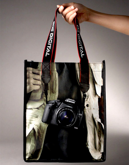 Сумка з щільним рекламним ремінцем і зображенням фотоапарата Canon.