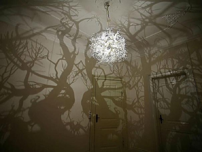 Интересное и очень крутое решение обустроить комнату с помощью люстры, которая превратит комнату в лес.