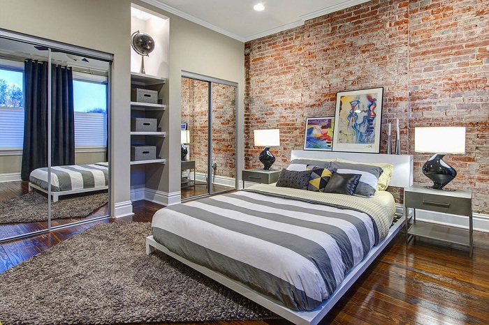Кирпичная стена — идеальный приём для спален, такой контрастный акцент зрительно расширяет пространство.