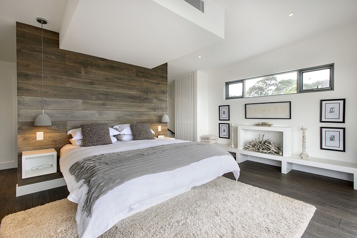 Хороший вариант правильно оформить интерьер спальной в серо-белых тонах и деревянной стеной.