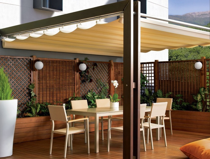 Веранда с раздвижной тентовой крышей - отличное решение для создания на свежем воздухе стильного и уютного место для отдыха.