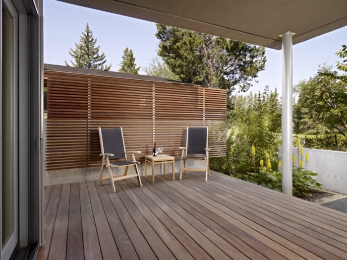 Открытая терраса с деревянной перегородкой может стать дополнительной комнатой на даче. 