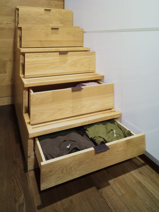 Выдвижные ящики для одежды, вмонтированные под лестничными ступеньками. 