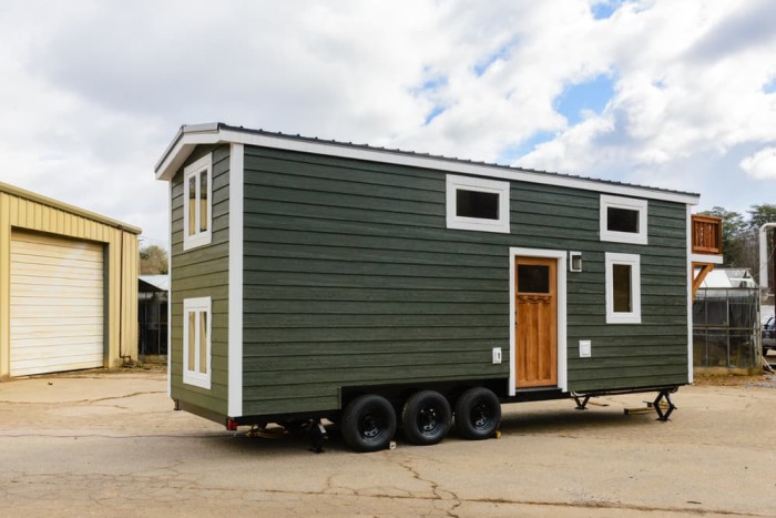 The tiny home looks a a little different with its green cladding and stained balcony