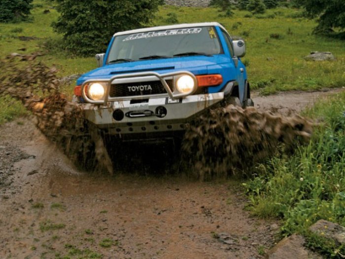 Лихо по грязи едет Toyota FJ Cruiser.