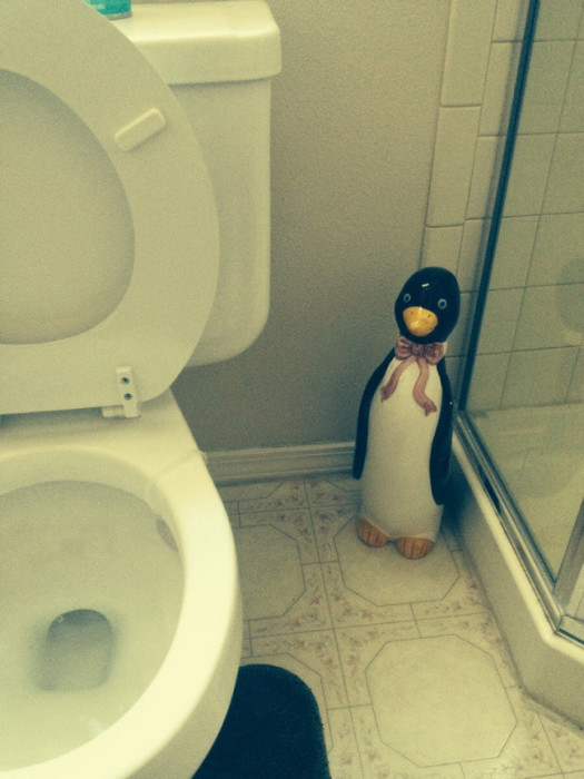 Статуя пингвина, стоящая в туалетной комнате.