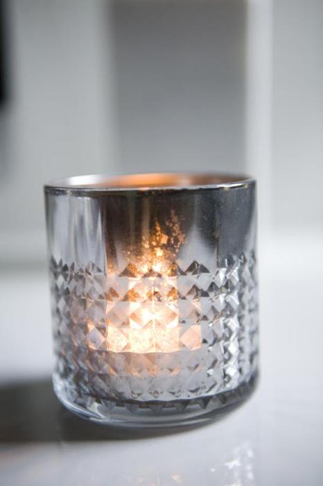 Оригінальний свічник сріблястого кольору зі скляного стакана.