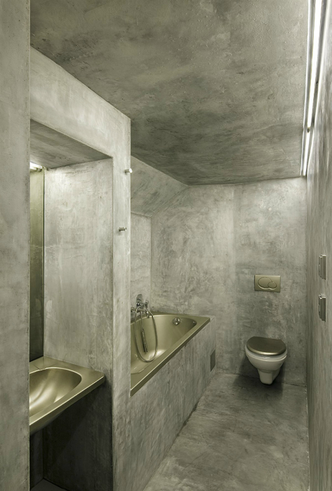 Вузька ванна кімната з сірими стінами.