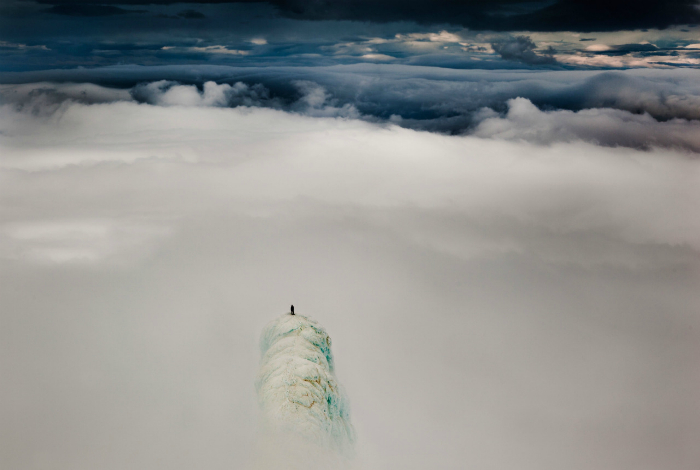 Альпинист, стоящий на вершине горы в Исландии.