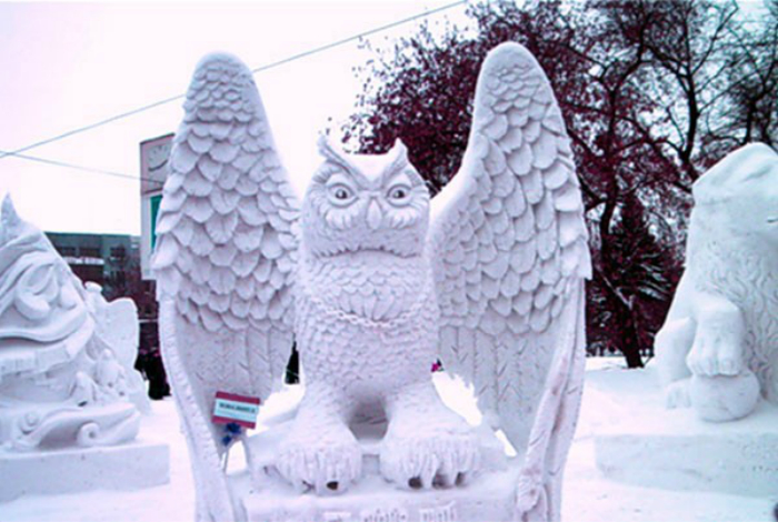 Замечательная скульптура в виде совы из снега.