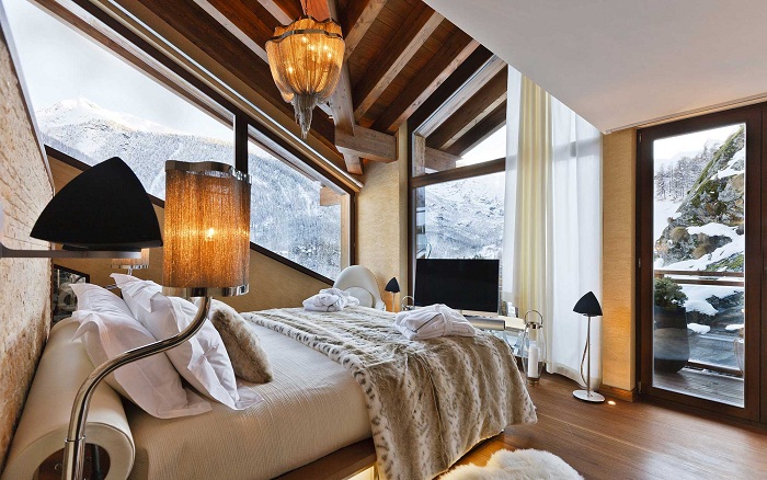 Теплая и уютная атмосфера спальной комнаты с красивым зимним видом из окна порадует глаз.