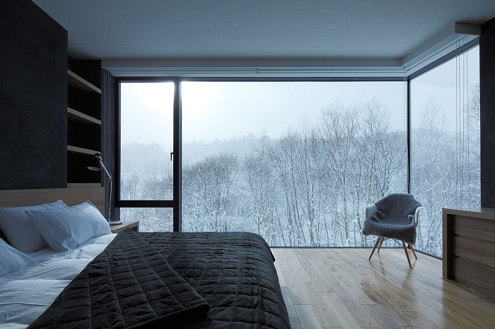 Спальня в черно-белых тонах с отличным видом на заснеженные деревья заставит погрузиться в мир фантазий и отдыха.