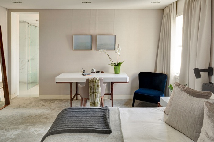 Світло-сірий інтер'єр спальної підкреслює особливий елемент декору - синє крісло.