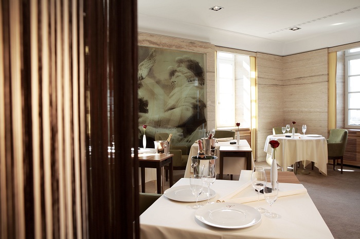 Этот классический ресторан изысканной кухни с элементами модерна, с минималистскими вазами с цветами на каждом столе.